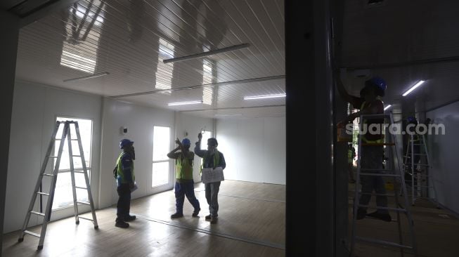 Pekerja menyelesaikan proyek rumah sakit rujukan virus Corona di kompleks Universitas Pertamina, Simprug, Jakarta, Sabtu (2/5). [Suara.com/Angga Budhiyanto]