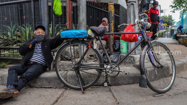 Pengojek sepeda ontel mangkal menunggu penumpang di kawasan Kota Tua, Jakarta Barat, Minggu (3/5). [Suara.com/Alfian Winanto]