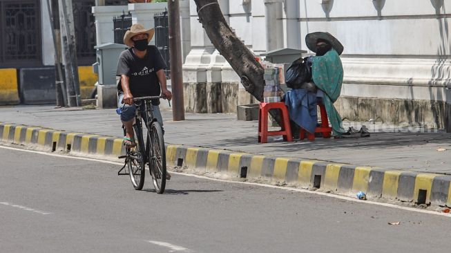 Ojek sepeda ontel melintas di kawasan Kota Tua, Jakarta Barat, Minggu (3/5). [Suara.com/Alfian Winanto]
