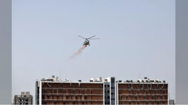 Di selatan kota Bengaluru, sebuah helikopter menghujani bunga-bunga di Rumah Sakit Victoria.[REUTERS/Amit Dave]