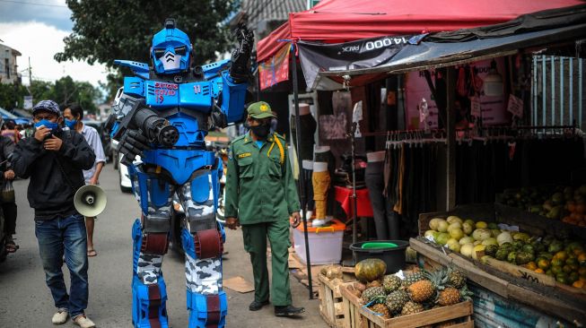 Petugas keamanan yang tergabung dalam Satuan Tugas Anti Nongkrong mengenakan kostum robot saat berpatroli keliling pasar di Sekepanjang, Bandung, Jawa Barat, Senin (4/5). . [ANTARA FOTO/Raisan Al Farisi]