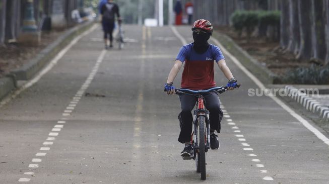 Warga berolahraga di kawasan Banjir Kanal Timur (BKT), Jakarta, Senin (4/5). [Suara.com/Angga Budhiyanto]