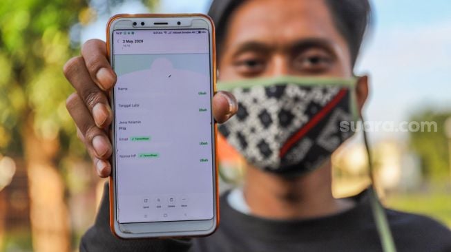 Pengguna aplikasi Tokopedia menunjukan akun Tokopedianya, Jakarta, Senin (4/5). [Suara.com/Alfian Winanto]