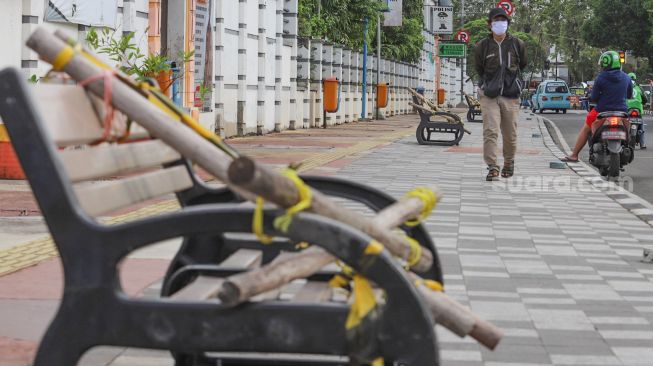 Warga beraktivitas di trotoar Rawamangun, Jakarta Timur, Senin (4/5). [Suara.com/Alfian Winanto]