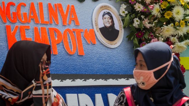 Pelayat melintas di depan karangan bunga duka cita almarhum Didi Kempot di rumah duka Sumber, Solo, Jawa Tengah, Selasa (5/5). [ANTARA FOTO/Mohammad Ayudha]