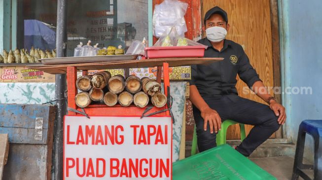 Pedagang menjajakan lemang yang sudah matang di Kramat Raya, Senen, Jakarta Pusat, Rabu (6/5). [Suara.com/Alfian Winanto]