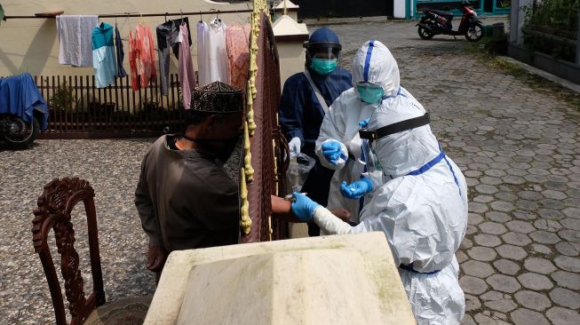 Petugas kesehatan mengambil sampel darah saat melaksanakan rapid test seorang anggota Jamaah Tabligh di Candiasri, Kedu, Temanggung, Jawa Tengah, Rabu (6/5). [ANTARA FOTO/Anis Efizudin]