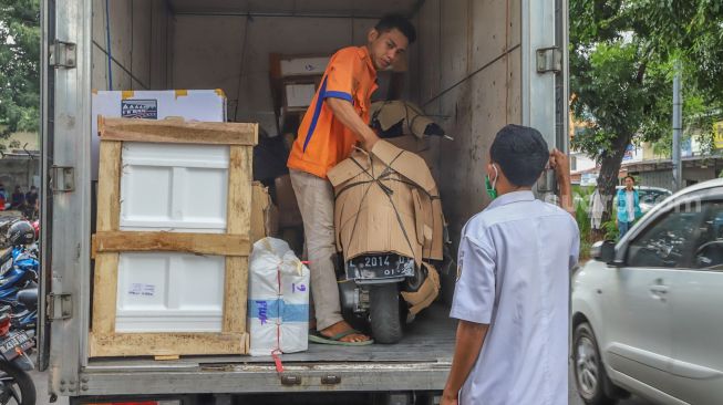 Petugas ekspedisi memasukan paket motor kedalam truk di Pasar Senen, Jakarta Pusat, Rabu (6/5). [Suara.com/Alfian Winanto]