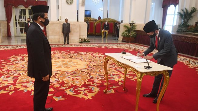 Presiden Joko Widodo (kanan) menandatangani surat pengangkatan Kepala Pusat Pelaporan dan Analisis Transaksi Keuangan (PPATK) Dian Ediana Rae dalam upacara pelantikan di Istana Negara, Jakarta, Rabu (6/5).  [ANTARA FOTO/Akbar Nugroho Gumay]