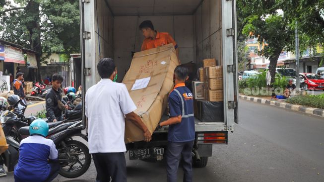 Petugas ekspedisi memasukkan paket barang kedalam truk untuk selanjutnya dikirim dengan kereta api di Pasar Senen, Jakarta Pusat, Rabu (6/5). [Suara.com/Alfian Winanto]