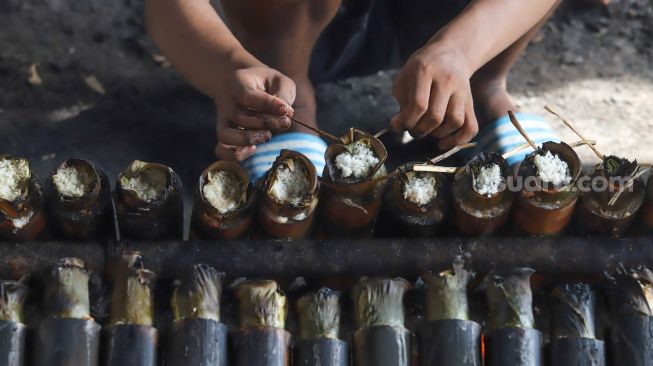 Pekerja mengikat ujung lemang di Kramat Raya, Senen, Jakarta Pusat, Rabu (6/5).  [Suara.com/Alfian Winanto]
