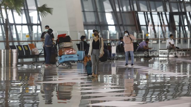 Sejumlah calon penumpang bersiap melakukan lapor diri sebelum terbang di Terminal 3 Bandara Soekarno Hatta, Tangerang, Banten, Kamis (7/5). [Suara.com/Angga Budhiyanto] 
