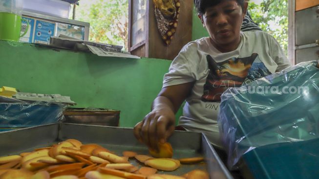 Pekerja membungkus kue di Pusaka Kwitang, Senen, Jakarta Pusat, Kamis (7/5). [Suara.com/Alfian Winanto]