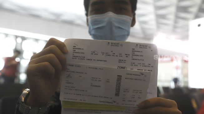 Seorang calon penumpang dengan ijin khusus kembali ke daerah asal usai menjalani pendidikan di Arab Saudi menunjukan surat syarat terbang di Terminal 3 Bandara Soekarno Hatta, Tangerang, Banten, Kamis (7/5).  [Suara.com/Angga Budhiyanto]