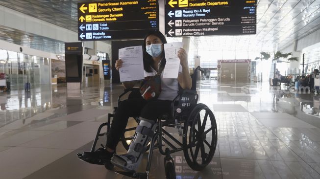 Seorang calon penumpang dengan ijin khusus berobat menunjukan surat syarat terbang di Terminal 3 Bandara Soekarno Hatta, Tangerang, Banten, Kamis (7/5).[Suara.com/Angga Budhiyanto]  