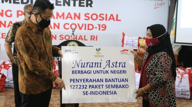 Menteri Sosial Republik Indonesia Juliari P. Batubara (kiri) menerima secara simbolis bantuan dari Head of Environment and Social Responsibility Astra Diah Suran Febrianti (kanan) di Kementerian Sosial RI, Jakarta (8/5/2020) [Dok Nurani Astra].