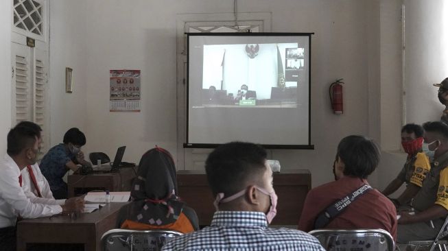 Sejumlah terdakwa kasus tindak pidana ringan pelanggaran perda penggunaan masker di Kabupaten Banyumas mengikuti proses sidang secara online di Pendopo Kecamatan Banyumas, Banyumas, Jateng, Jumat (8/5). [ANTARA FOTO/Idhad Zakaria]