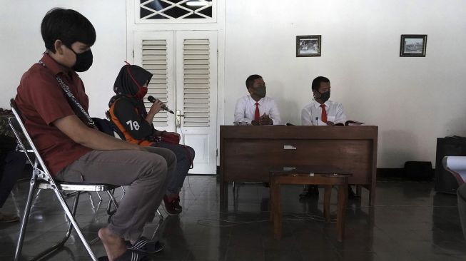 Sejumlah terdakwa kasus tindak pidana ringan pelanggaran perda penggunaan masker di Kabupaten Banyumas mengikuti proses sidang secara online di Pendopo Kecamatan Banyumas, Banyumas, Jateng, Jumat (8/5). [ANTARA FOTO/Idhad Zakaria]