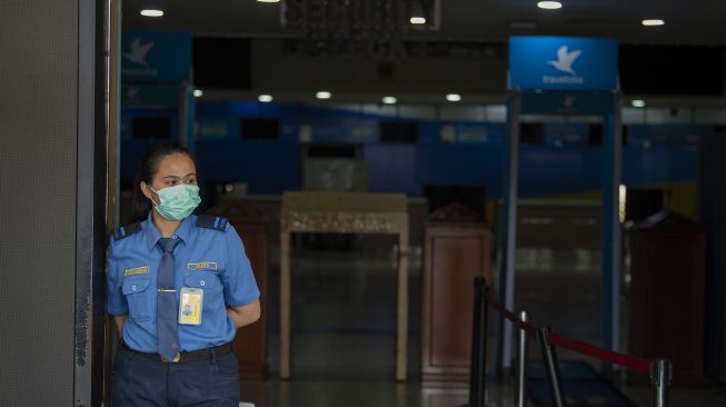 Petugas berdiri di pintu kedatangan Bandara Halim Perdanakusuma yang tertutup di Jakarta, Kamis (7/5). [ANTARA FOTO/Aditya Pradana Putra]