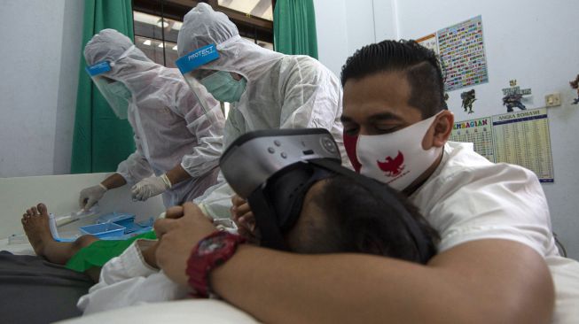 Petugas medis dari Rumah Sunat dr Mahdian mengkhitan di rumah pasien di Gaga, Ciledug, Tangerang Selatan, Banten, Jumat (8/5). [ANTARA FOTO/Aditya Pradana Putra]