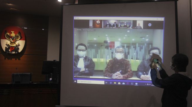 Tayangan video conference (vicon) yang menayangkan terdakwa mantan Dirut Garuda Indonesia Emirsyah Satar (kedua kiri) menjalani sidang pembacaan putusan di gedung KPK, Jakarta, Jumat (8/5).  [ANTARA FOTO/Reno Esnir]