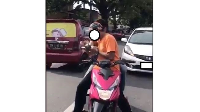 Adegan pemotor makan saat mengendarai motor Honda BeAT di jalan (Facebook-ALifah Nisa)