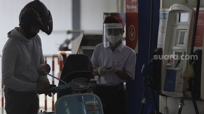 Petugas SPBU menggunakan alat pelindung wajah saat melayani pengendara di SPBU 31-164-01, Margonda, Depok, Jawa Barat, Sabtu (9/5). [Suara.com/Angga Budhiyanto]