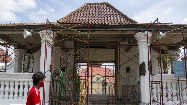 Pekerja menyelesaikan perawatan gerbang Masjid Gede Kauman di Yogyakarta, Sabtu (9/5). [ANTARA FOTO/Hendra Nurdiyansyah]