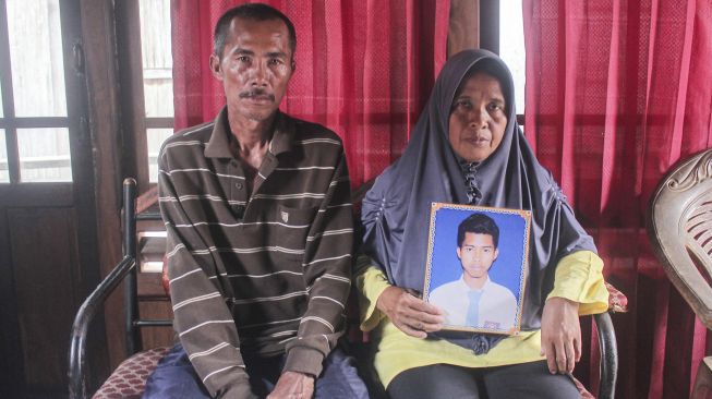 Orang tua dari Ari (24), salah satu Anak Buah Kapal (ABK) Long Xing 629 menunjukkan foto anaknya di Desa Serdang Menang, Sirah Pulau Padang, Kabupaten Ogan Komering Ilir, Sumatera Selatan, Sabtu (9/5).  [ANTARA FOTO/Triyan Wahyudi]