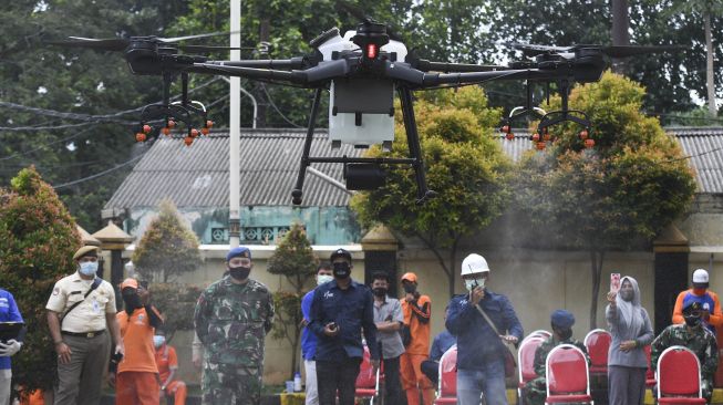 Sebuah pesawat nirawak atau drone menyemprotkan cairan disinfektan di kawasan Pancoran, Jakarta, Senin (11/5).  [ANTARA FOTO/Hafidz Mubarak ]
