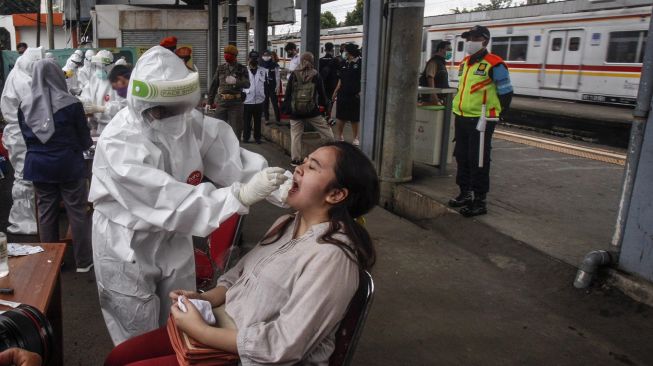 Petugas medis mengambil sampel lendir dari penumpang KRL saat tes swab Corona COVID-19 di Stasiun Bojong Gede, Bogor, Jawa Barat, Senin (11/5/2020).  [ANTARA FOTO/Yulius Satria Wijaya]
