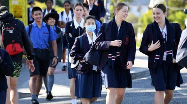 Murid-murid tiba di lokasi di Brisbane, Australia, Senin (11/5/2020), pada hari pertama bersekolah secara tatap muka setelah mereka beberapa waktu belajar secara daring dari rumah untuk mencegah penyebaran wabah virus corona (COVID-19). (ANTARA/AAP Image/Dan Peled via REUTERS/TM)