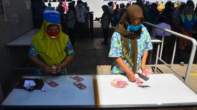 Sejumlah Pekerja menghitung uang Tunjangan Hari Raya (THR) Lebaran yang diterimanya di pabrik rokok PT Djarum, Kudus, Jawa Tengah, Selasa (12/5). [ANTARA FOTO/Yusuf Nugroho]
