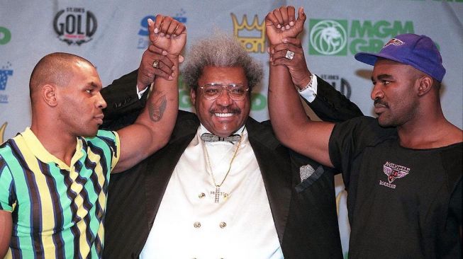 Promotor Don King mengapit Mike Tyson (kiri) dan Evander Holyfield dalam sesi konferensi pers jelang duel kedua petinju di MGM Grand, Las Vegas, 25 Juni 1997. [AFP/John Gurzinski]