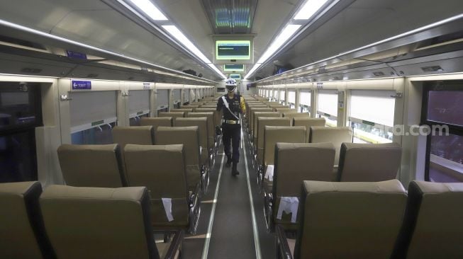 Petugas keamanan melakukan pengecekan di dalam gerbong Kereta Api Luar Biasa jurusan Gambir-Surabaya Pasar Turi yang berangkat dari Stasiun Gambir, Jakarta, Rabu (13/5). [Suara.com/Angga Budhiyanto]