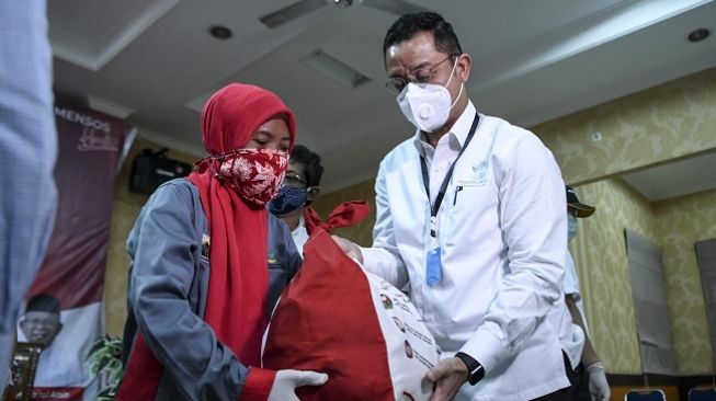 Menteri Sosial Juliari P Batubara (kanan) memberikan paket bantuan kepada penghuni penampungan sementara warga terdampak COVID-19 di Balai Rehabilitasi Watunas Mulya Jaya, Jakarta, Senin (11/5/2020). (ANTARA FOTO/Hafidz Mubarak)