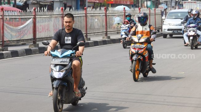 Warga beraktivitas diluar rumah tanpa menggunakan masker di kawasan Jatinegara, Jakarta Timur, Rabu (13/5). [Suara.com/Alfian Winanto]