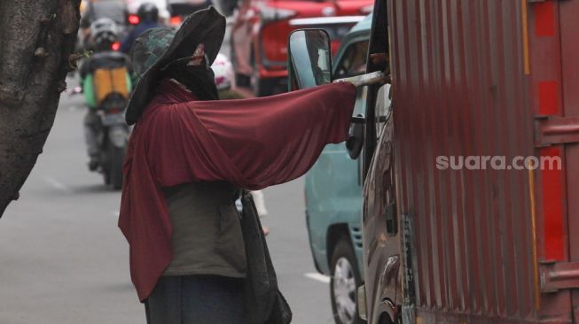 Pengendara truk menukar pecahan uang baru di kawasan Kota Tua, Jakarta Barat, Kamis (14/5). [Suara.com/Alfian Winanto]
