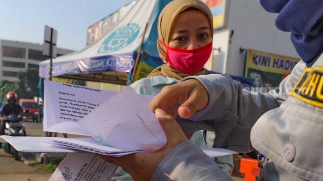 Petugas memeriksa surat tugas kantor para penumpang yang akan bekerja menggunakan transportasi Kereta Rel Listrik (KRL) di Stasiun Depok Baru, Depok, Jawa Barat, Jumat (15/5). [Suara.com/Alfian Winanto]