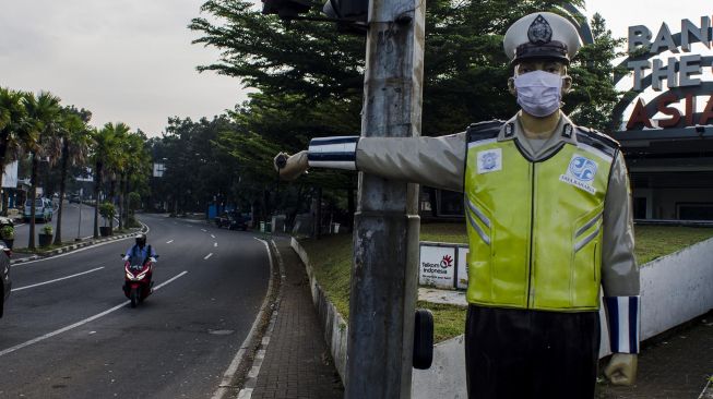 Patung polisi lalu lintas yang terletak di ruas jalan dipasangkan masker di Bandung, Jawa barat, Jumat (15/5).  [ANTARA FOTO/Novrian Arbi]