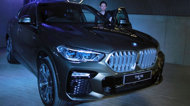 Model berpose disamping mobil "The New BMW X6" saat peluncurannya yang dilakukan secara virtual di Serpong, Tangerang Selatan, Banten, Jumat (15/5).  [ANTARA FOTO/Muhammad Iqbal]