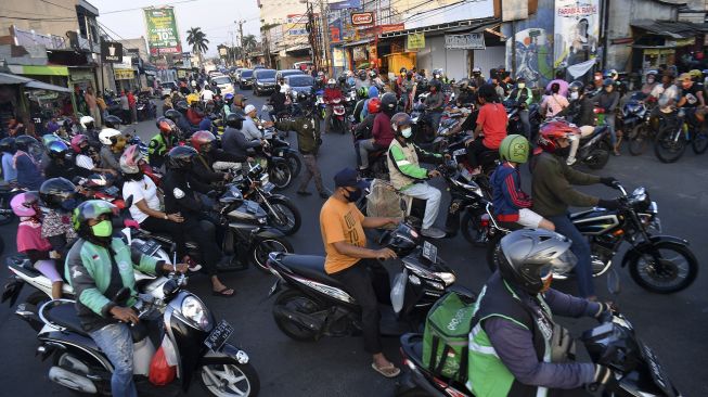 Puluhan pengendara sepeda motor melintas di Jalan Raya Sawangan, Depok, Jawa Barat, Sabtu (16/5). [ANTARA FOTO/Sigid Kurniawan]