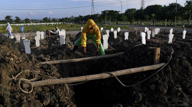 Petugas menyiapkan liang lahat untuk jenazah kasus COVID-19 di Tempat Pemakaman Umum (TPU) Keputih, Surabaya, Jawa Timur, Sabtu (16/5). [ANTARA FOTO/Zabur Karuru]