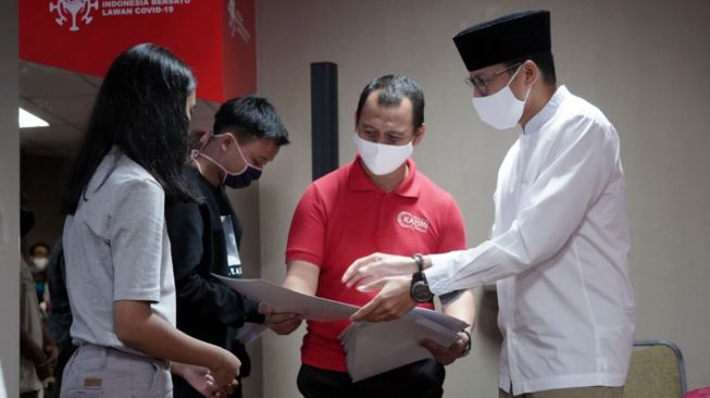 Tokoh inspirator entrepreneur Nasional Sandiaga Uno (kanan) menyerahkan beasiswa KAHMIPreneur Ke sejumlah Pelajar dan Mahasiswa Berjiwa wirausaha di Jakarta, Kamis (14/05).  [Suara.com/OkeAtmaja]