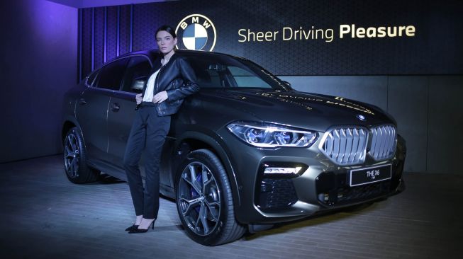 Model berpose disamping mobil "The New BMW X6" saat peluncurannya yang dilakukan secara virtual di Serpong, Tangerang Selatan, Banten, Jumat (15/5).  [ANTARA FOTO/Muhammad Iqbal]