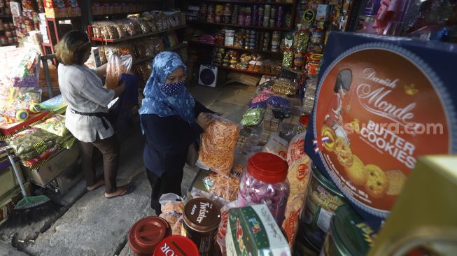 Calon pembeli memilih kue kering dalam kemasan di kawasan Ciracas, Jakarta, Sabtu (16/5).  [Suara.com/Angga Budhiyanto]