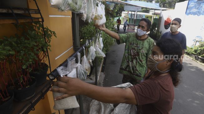 Warga mengambil paket sembako gratis di kawasan Jati Padang, Jakarta, Minggu (17/5). [Suara.com/Angga Budhiyanto]