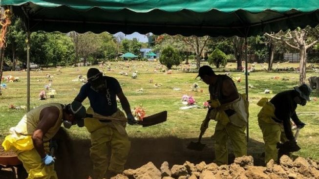 Penggali makam menutup lobang kubur jenazah pasien virus corona di Nicaragua. [AFP]