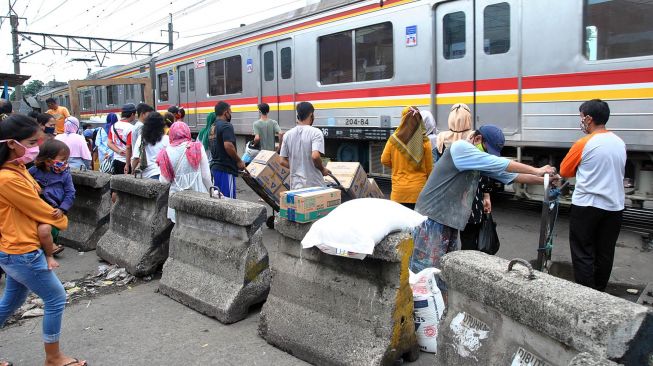 Sejumlah warga menunggu KRL Commuter Line lewat di perlintasan Pasar Anyar yang ditutup beton di Kota Bogor, Jawa Barat, Selasa (19/5).  [ANTARA FOTO/Arif Firmansyah]
