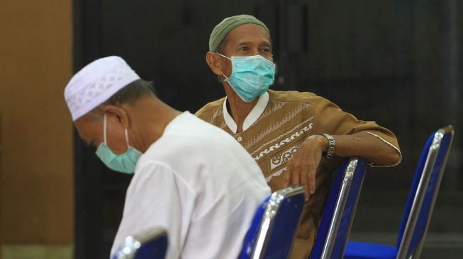 Dua dari delapan pasien positif yang telah sembuh dari COVID-19 duduk menunggu acara pelepasan kepulangan mereka di Dinas Kesehatan Provinsi Kalbar di Pontianak, Senin (18/5).  [ANTARA FOTO/Jessica Helena Wuysang]
